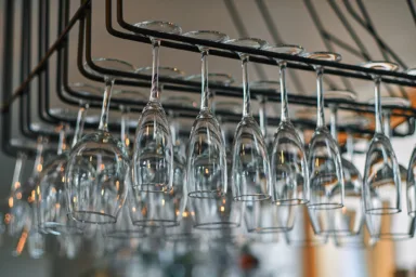 Wine glasses hanging above a bar counter